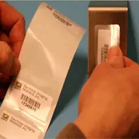 hand placing the clear/laminate label on top of the slightly smaller, printed label