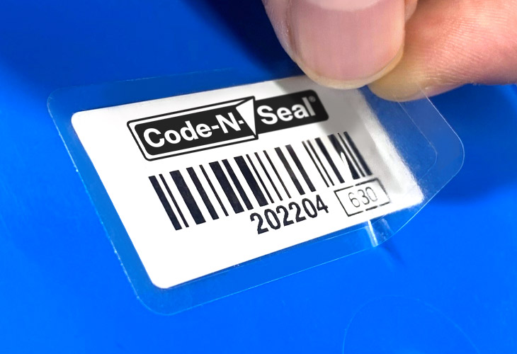 Close-up image of a hand applying a clear laminate over the top of an asset label.