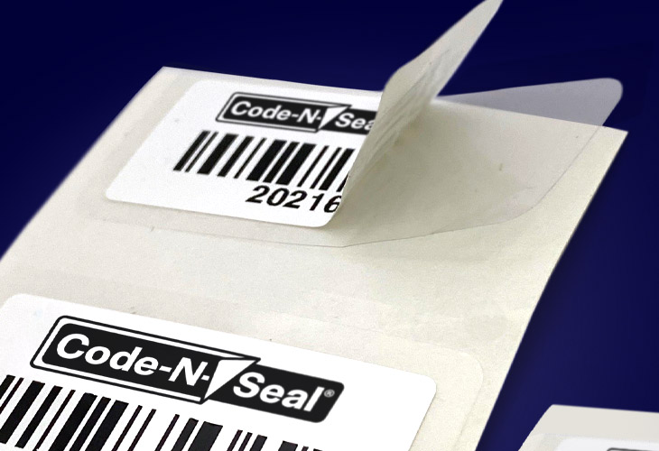 Code-N-Seal self-laminating label on liner with navy blue background.