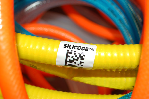Pile of multi-colored silicone hoses with a black and white SiliCode labeled adhered to the center.