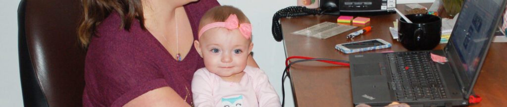 Baby Savannah and mom Jillian working at a desk