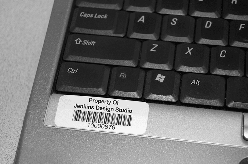 Paper barcode asset label on a laptop