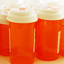 Orange plastic prescription pill containers with white lids