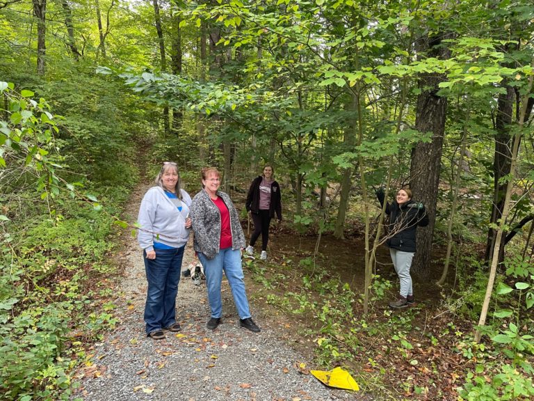 4 label experts outdoors on a wooded pathway