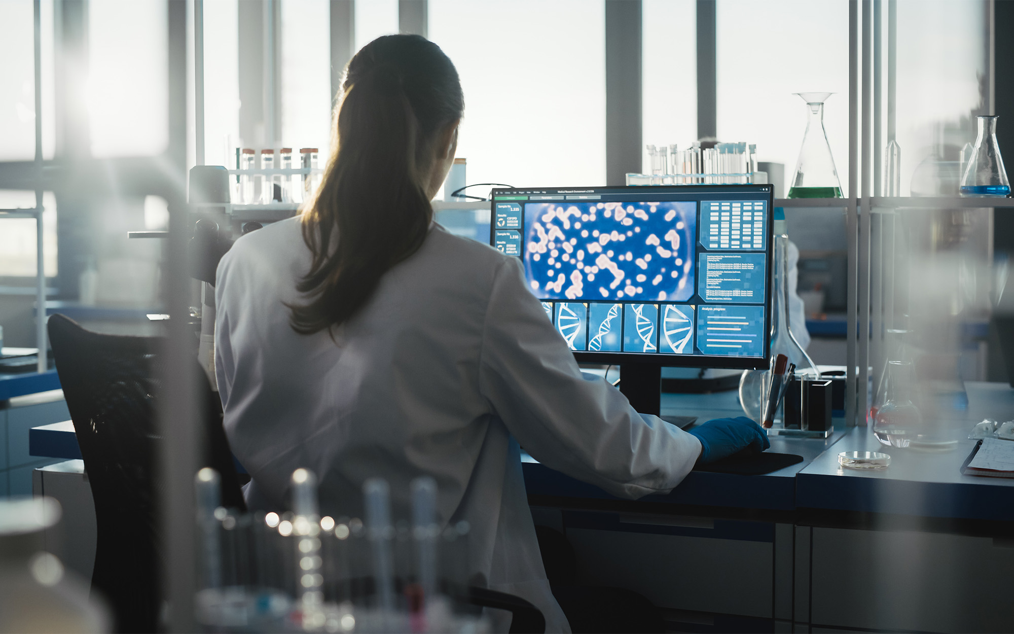 Female Biochemist Working on Computer Showing Gene Therapy Interface