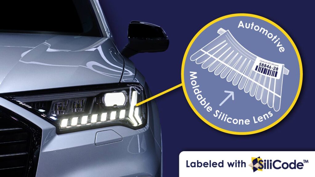 Automotive silicone lens labeled with a SiliCode barcode inside circle pointing towards car headlight