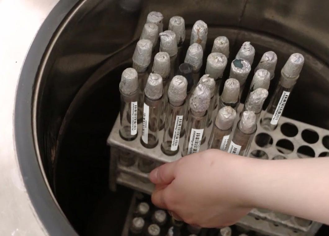 Labeled sample tubes getting lifted from Autoclave sterilizer