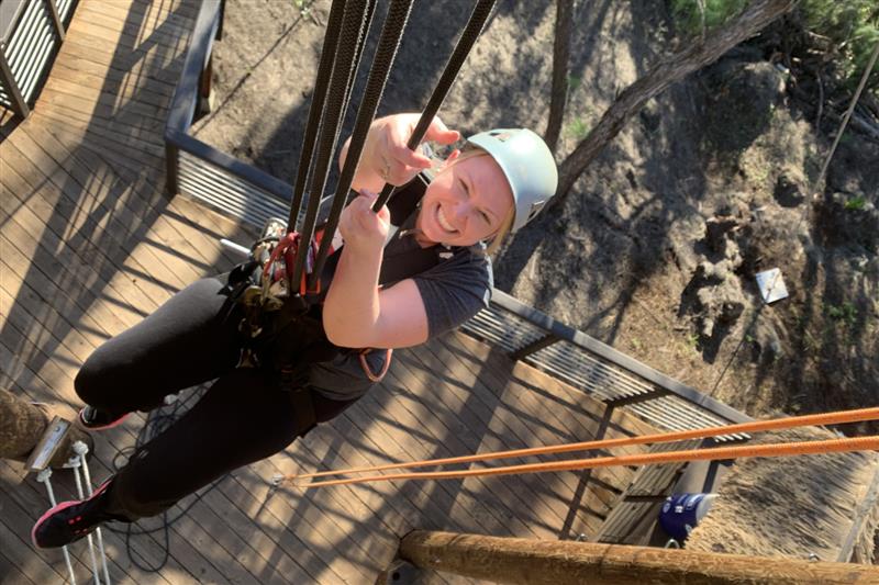 Human Resources Ashley descending down using a rope during an exciting excursion.