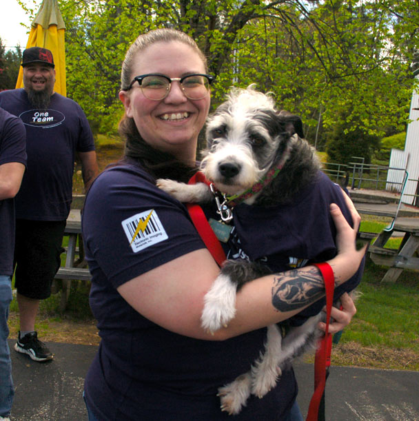 EIM Human Resources and Payroll Administrator Tanya Amato holding her pet dog Winnie.